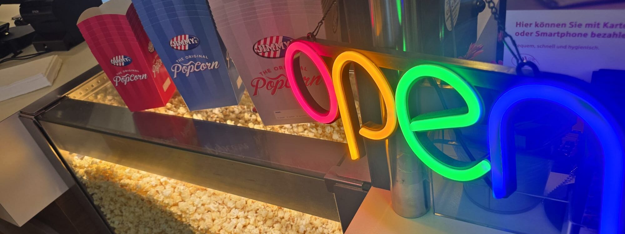 Popcon und Popcorntüten in blau und rosa, Schild "open"