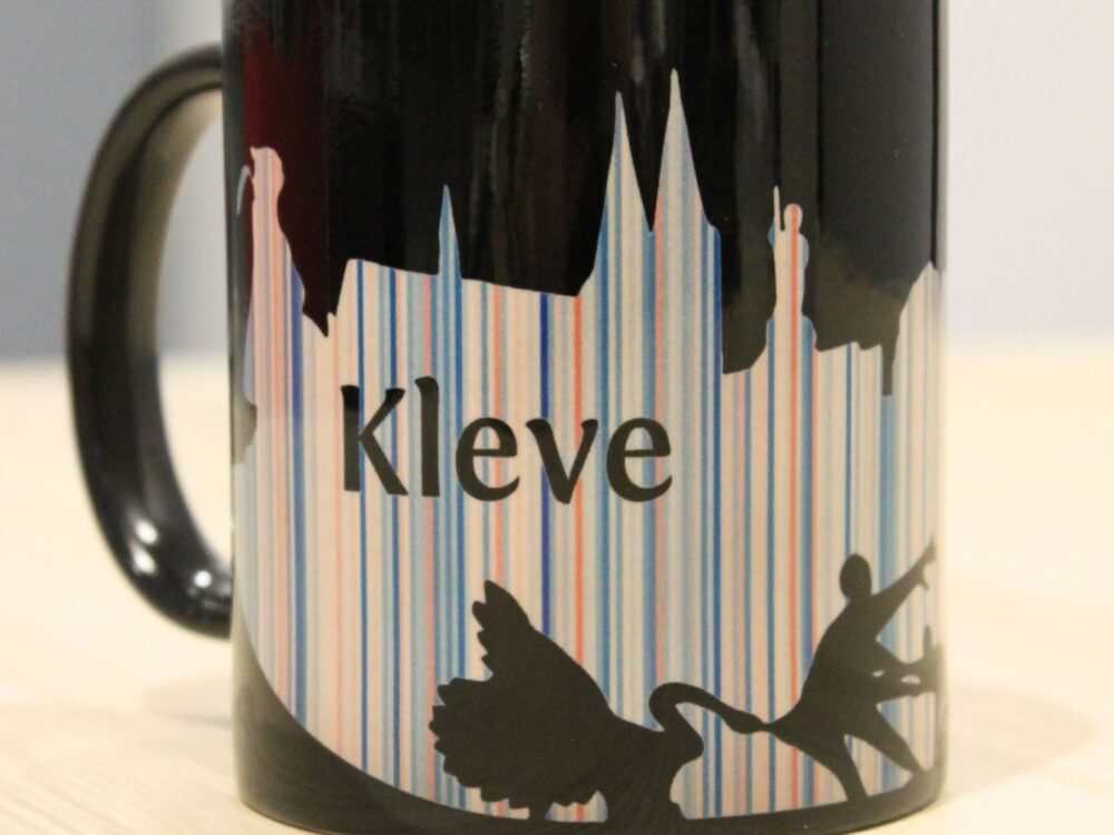 schwarze Tasse mit der Silhouette von Kleve in bunten Warming Stripes
