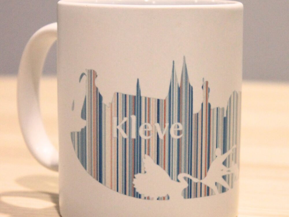 weiße Tasse mit der Silhouette von Kleve in bunten Warming Stripes