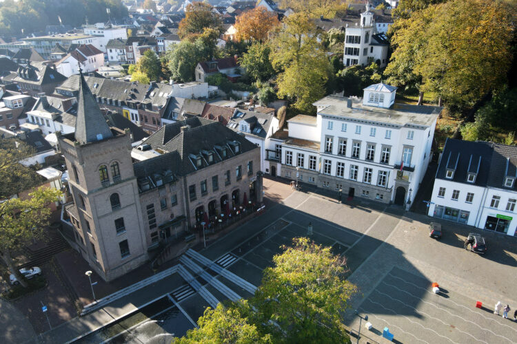 Sicht von oben auf Turm, Marktplatz und ein weißes Gebäude.