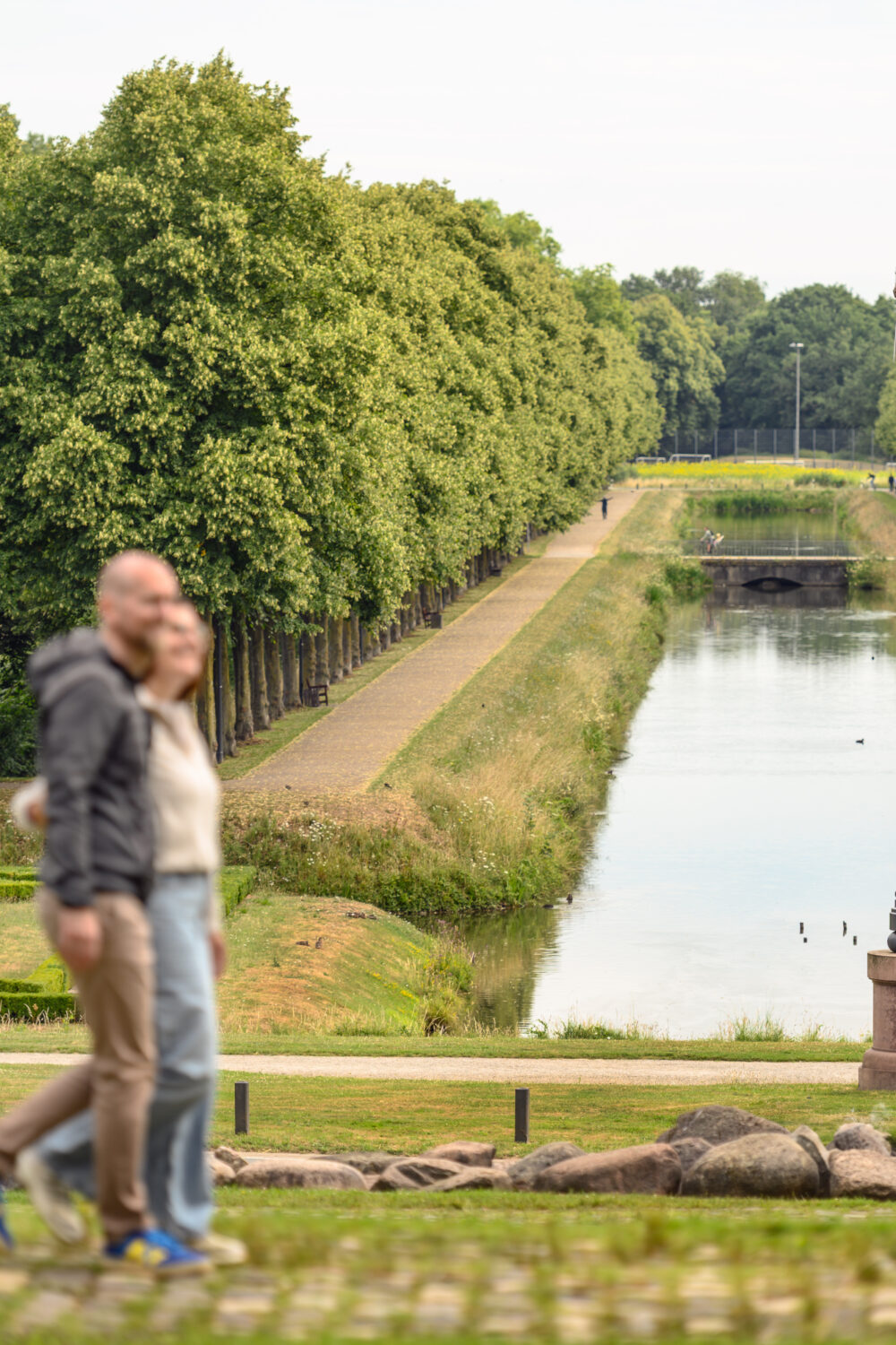 Zwei Spaziergänger wandern durch einen Park.