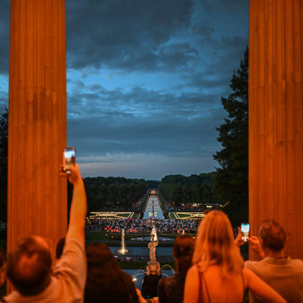 Menschen fotografieren beleuchtete Gartenanlagen beim Klever Lichterfest