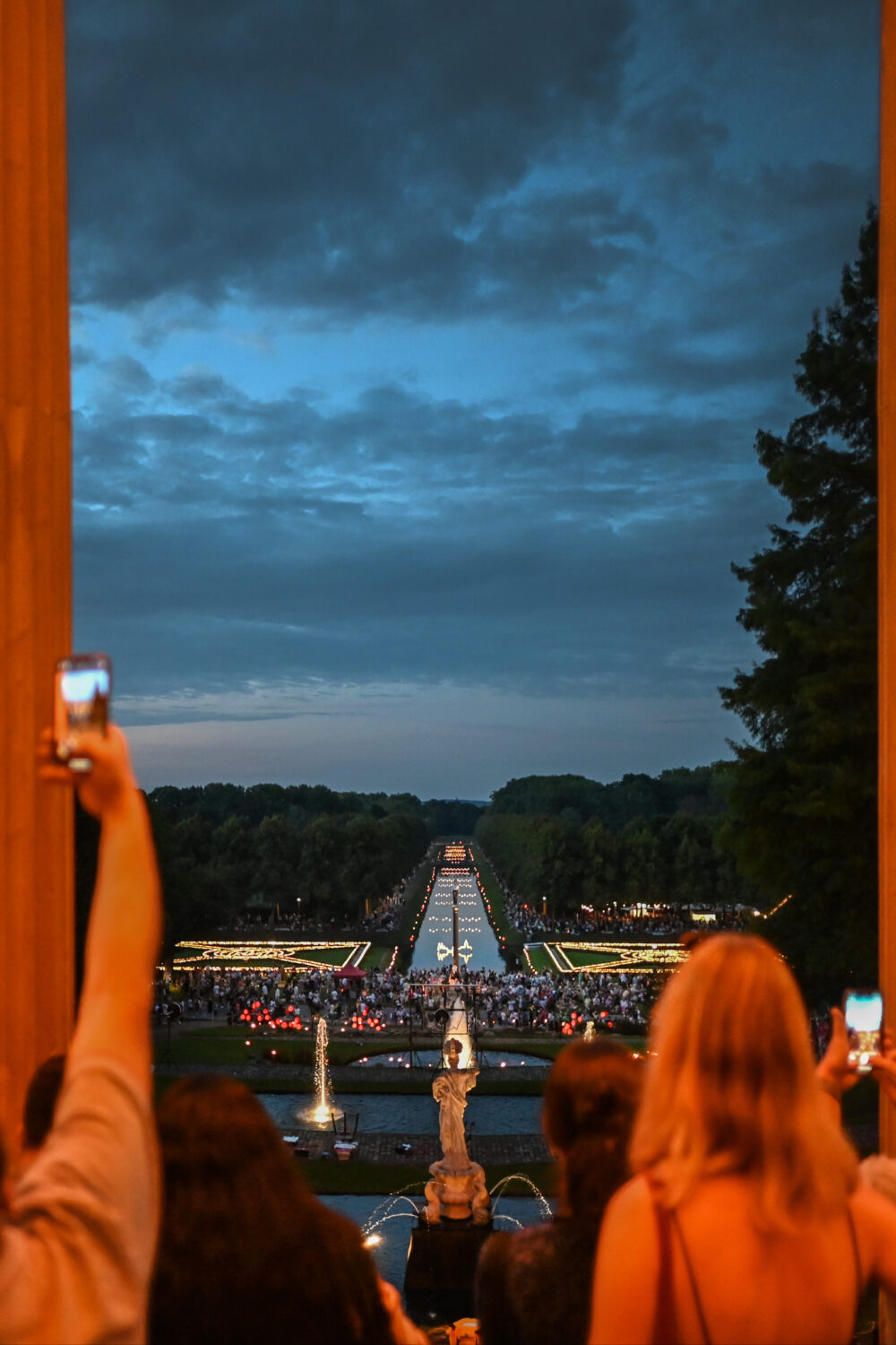 Menschen fotografieren beleuchtete Gartenanlagen beim Klever Lichterfest
