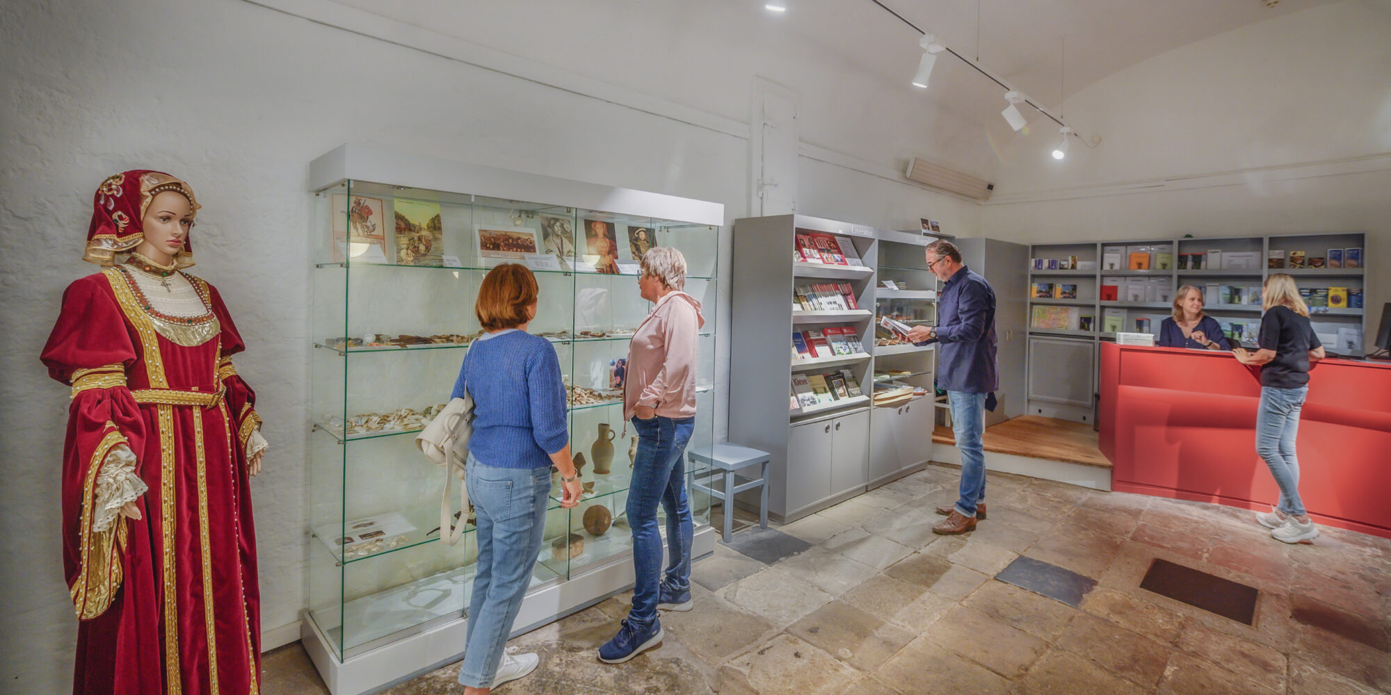 mehrere Personen halten sich im Eingangsbereich des Schwanenturms auf, links eine Schaufensterpuppe mit dem Gewand von Anna von Cleve