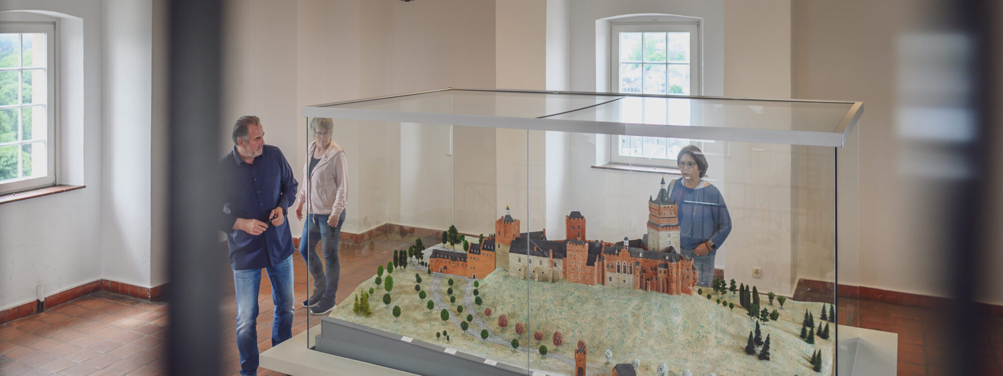 Personen betrachten das Modell der Schwanenburg