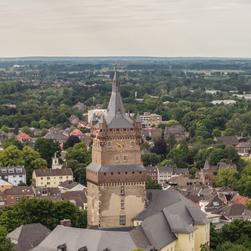 Blick aus der Luft auf die Schwanenburg inmitten der Stadt Kleve mit Bäumen im Vordergrund