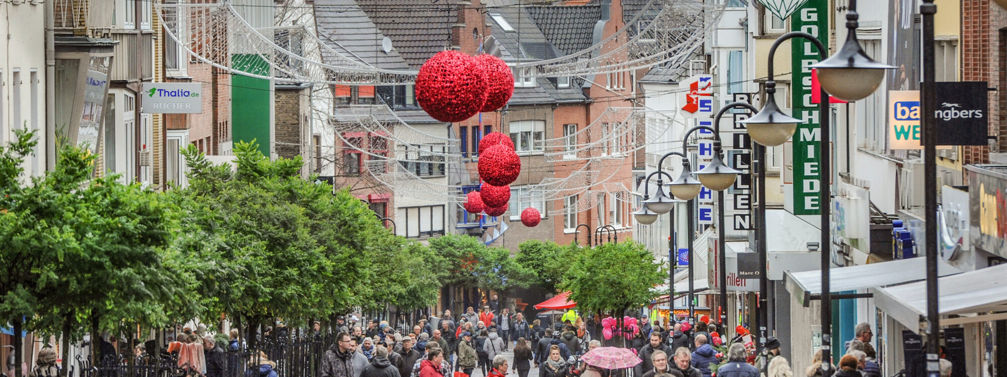 Menschen befinden sich in einer Innenstadt mit Weihnachtsbeleuchtung