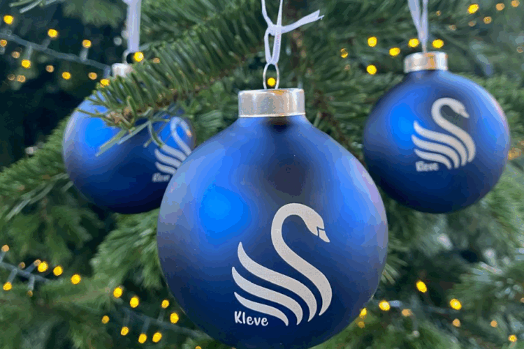 Blaue Weihnachtskugel mit dem Schwan und dem Kleve-Schriftzug in einem Tannenbaum