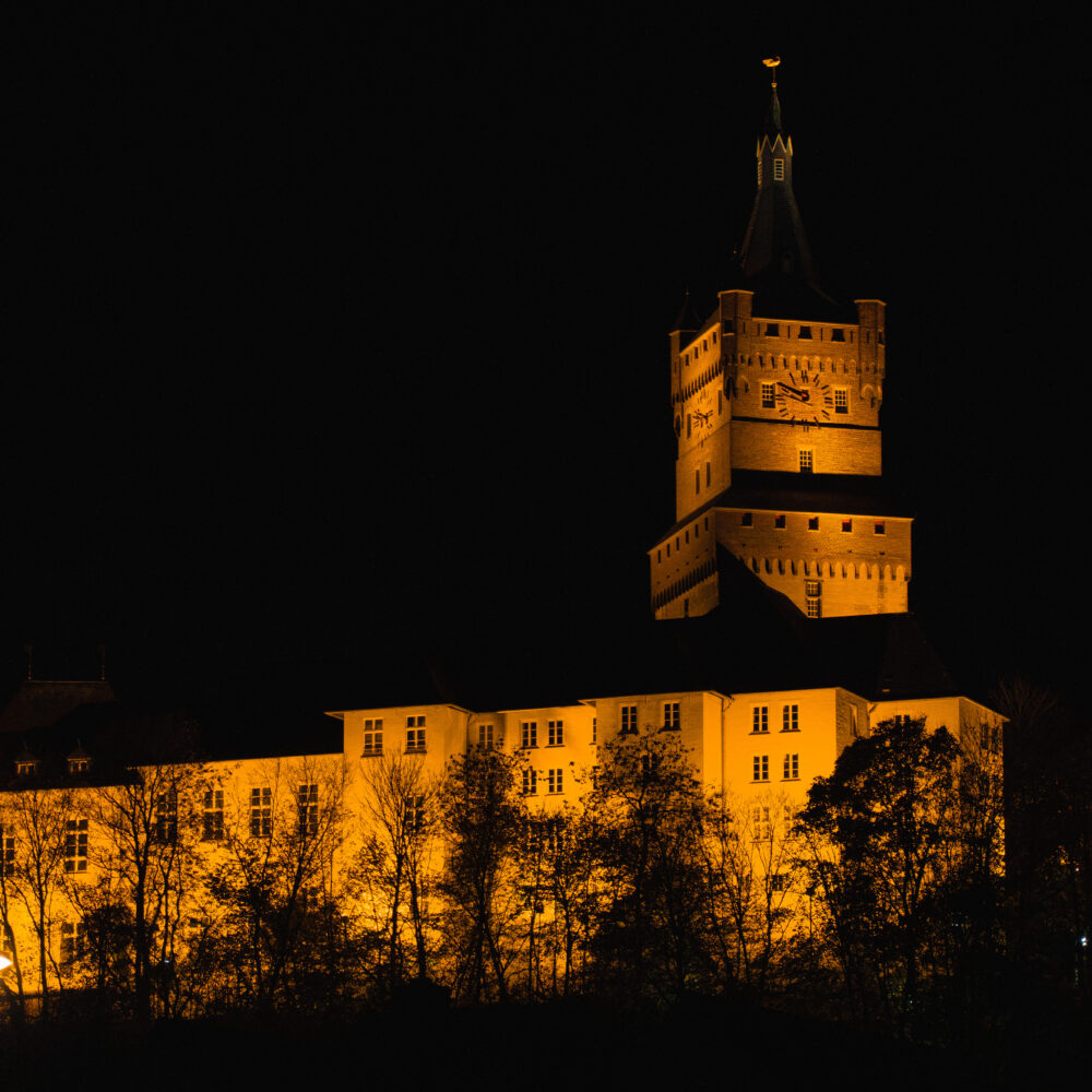 Beleuchtete Burg in der Dunkelheit.