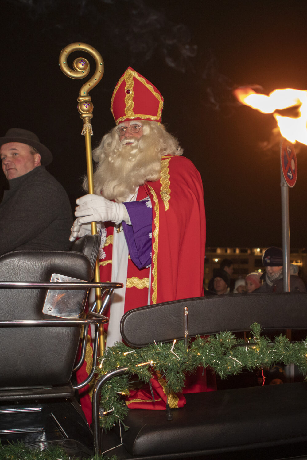 Mann verkleidet als Nikolaus sitzt auf einer Kutsche.