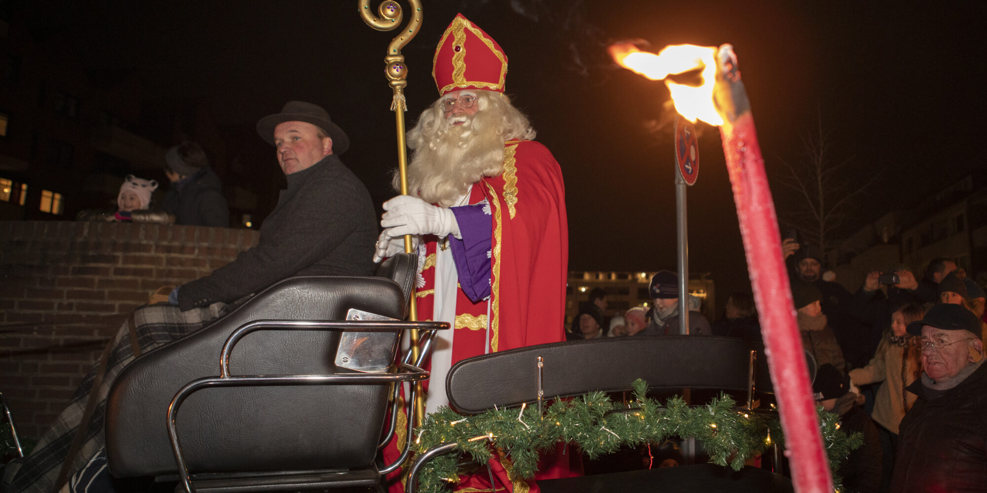 Mann verkleidet als Nikolaus sitzt auf einer Kutsche.