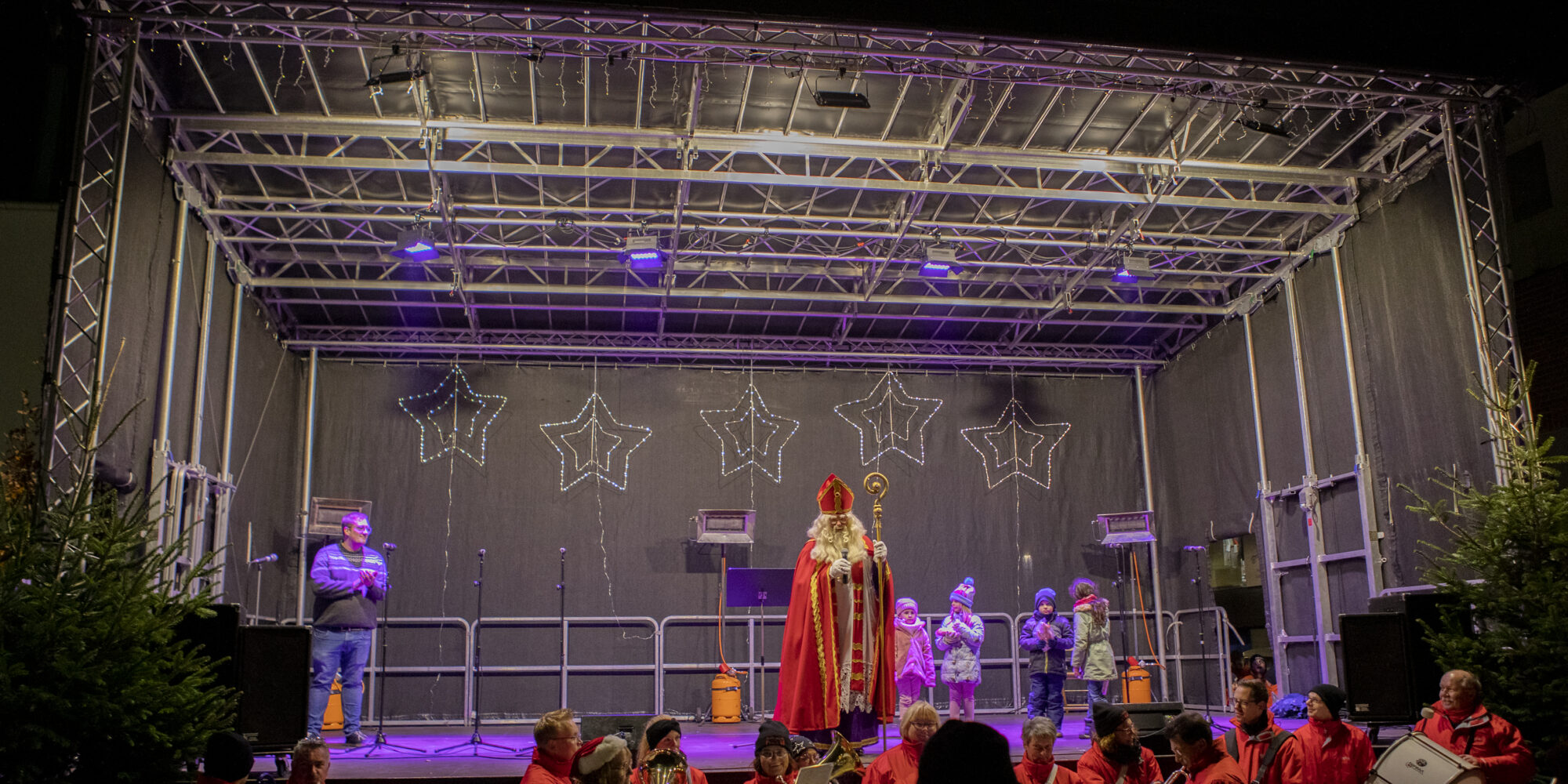 Der Nikolaus steht auf einer geschmückten Bühne.