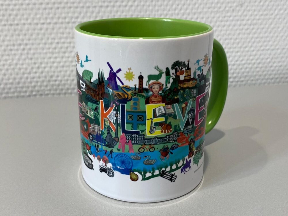Weiße Tasse mit grünem Henkel und Innenfläche, bedruckt mit einer farbigen Illustration und dem Schriftzug 'Kleve' designt von Maren Rombold.