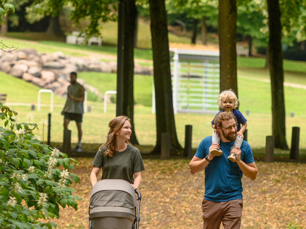 Ein Paar mit Kind und Kinderwagen in den Gartenanlagen in Kleve