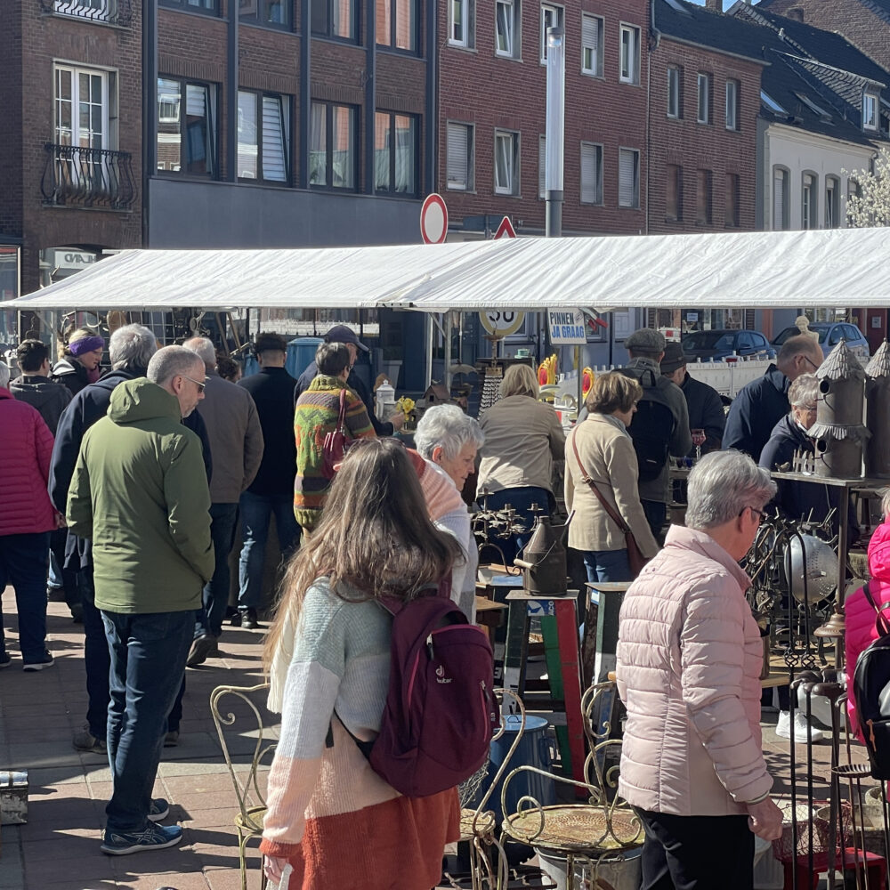 Menschen schlendern entlang des Brocante-Marktes