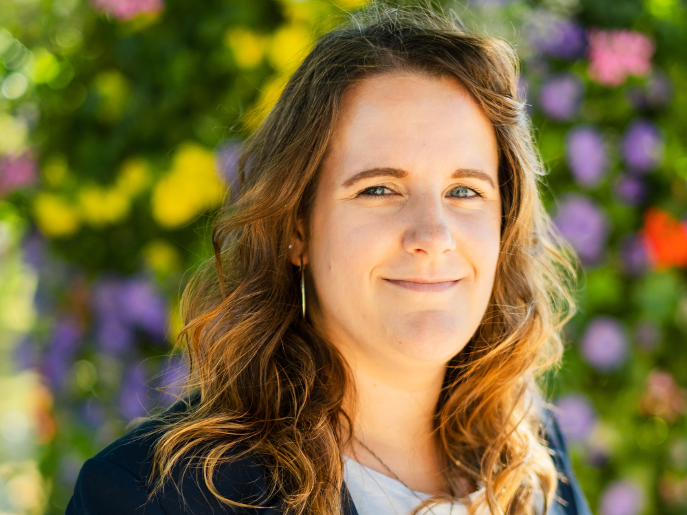 Christina Danisewicz im Vordergrund, im Hintergrund sind bunte Blumen