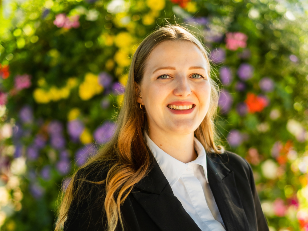 Antonia Pieper im Vordergrund, im Hintergrund sind bunte Blumen