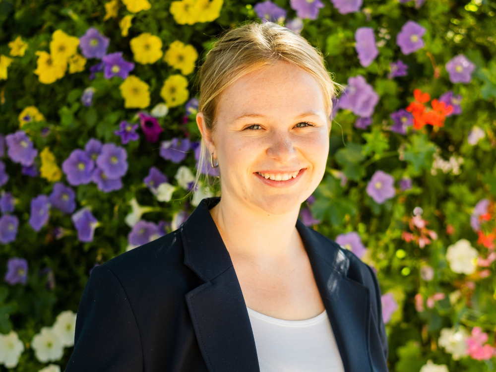 Janneke Nienhaus im Vordergrund, im Hintergrund sind bunte Blumen